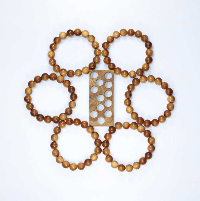 Buy natural sandalwood bracelet collection arranged around a wooden bead-sizing board