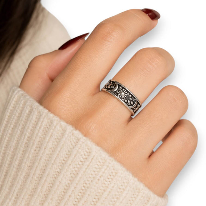 woman wearing middle finger Cosmic Open Band Ring with silver sun, moon, star, and beaded celestial details