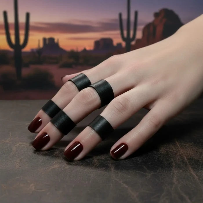 Black leather band rings set with silver geometric hardware and five assorted stackable ring sizes