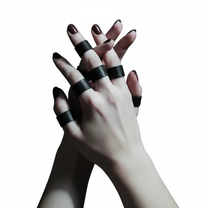 Black leather band rings set with silver geometric hardware and five assorted stackable ring sizes