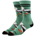 A pair of Stinks brand crew socks in sage green, featuring a graphic print of bald eagles and coqui frogs, with black stripes near the top and black heels and toes.