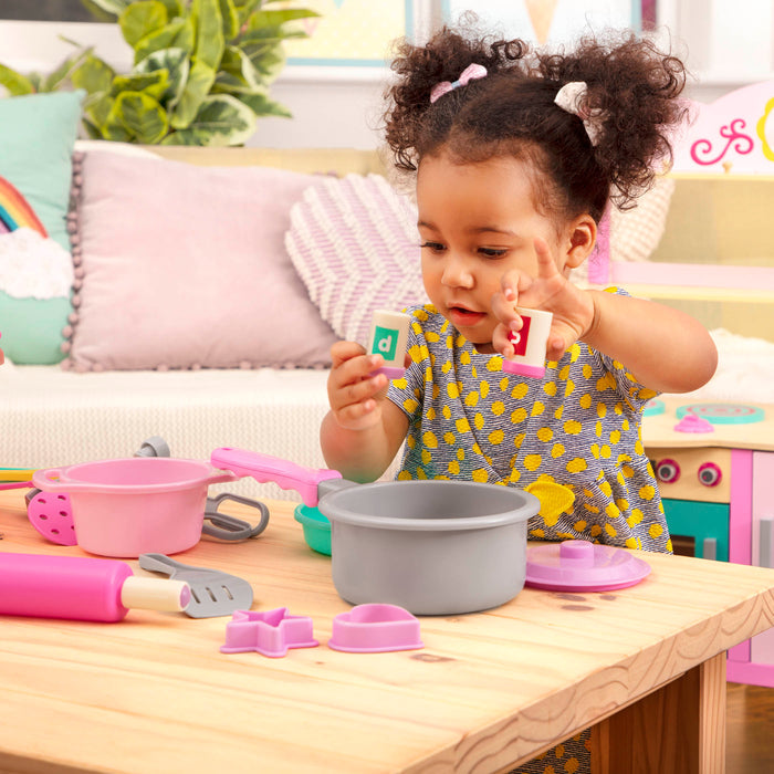 A colorful set of kitchen toys with a bin to store verything in.