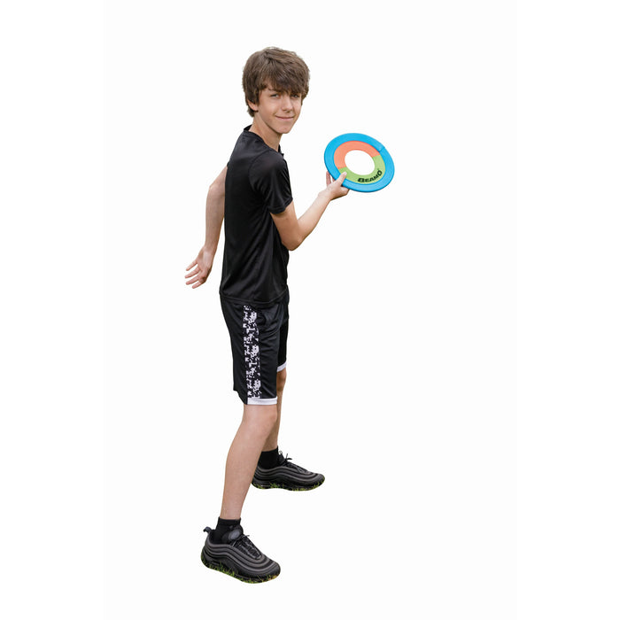 A teenage boy in a black athletic outfit and sneakers holds the GO! Play-Beamo 10in Flying Disc, ready to throw it against a white background—ideal for outdoor fun.
