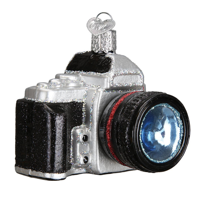 Handblown glass ornament in the shape of a camera, with black, silver, and red colors, and detailed features such as a lens and flash.