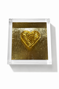 A square clear acrylic block containing a textured gold background and a raised metallic gold heart in the center, photographed on a clean white background.