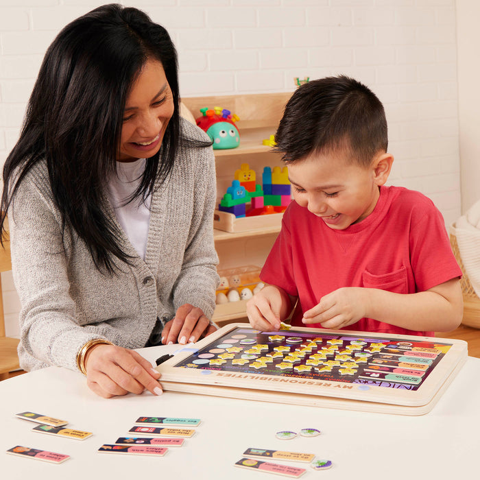 Space-themed responsibility chart with magnets, booklet, and dry-erase marker.