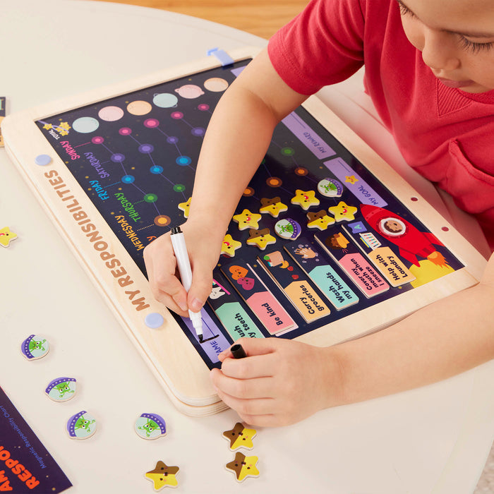 Space-themed responsibility chart with magnets, booklet, and dry-erase marker.