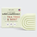 A solid conditioner bar with packaging that reads 'Kitsch Clarifying Solid Conditioner Tea Tree & Mint'. The bar is pale green with the brand name Kitsch at the top.