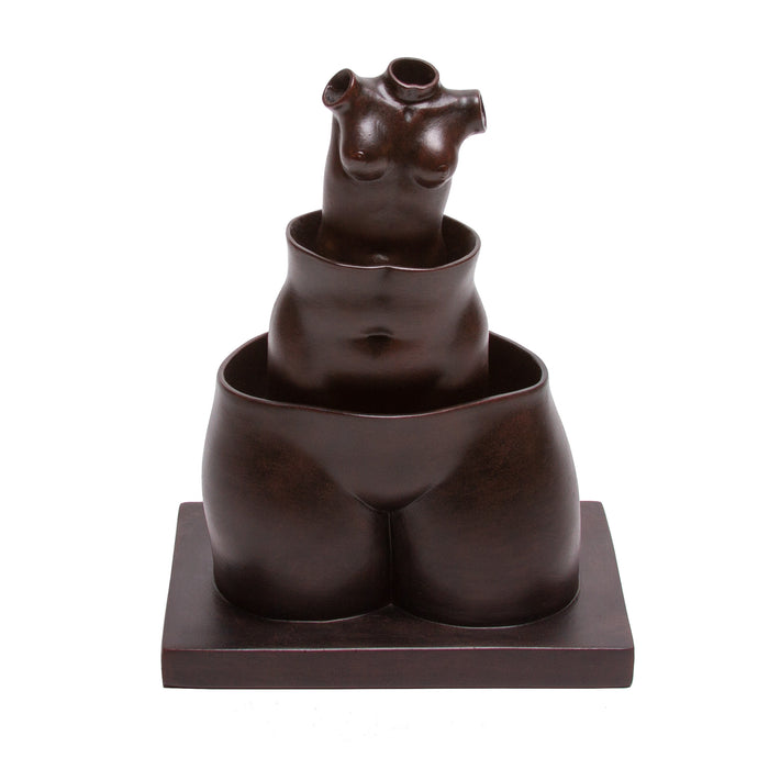 A sculpture reproduction of Rene Magritte's work featuring three hollow female forms stacked within each other on a square base, with a pair of robust thighs as a base. The sculpture is dark in color, with a matte finish.