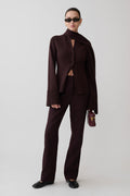 Woman wearing a dark brown cardigan with scarf.
