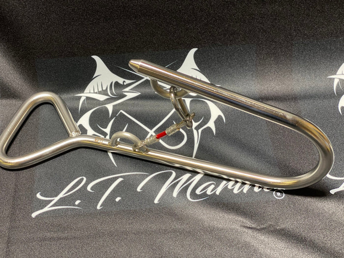 A stainless steel commercial tuna swim hook with a safety tether and eye loop, displayed on a fabric with the logo of L.T.