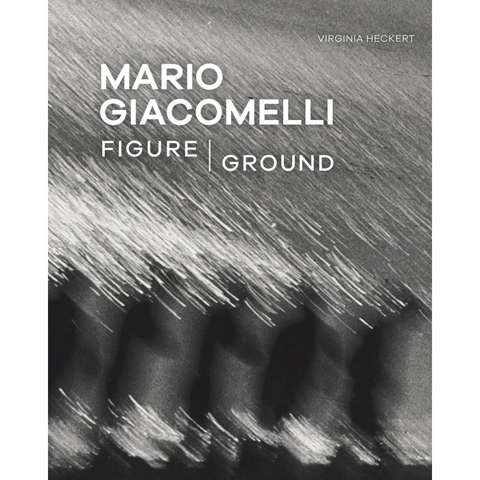 This image features the cover of the book "Mario Giacomelli: Figure/Ground" curated by Virginia Heckert. The cover showcases a monochrome photograph of what appears to be dynamic, blurred light trails, possibly on water, capturing the essence of Giacomelli's bold, geometric compositions with glowing whites and deep blacks.