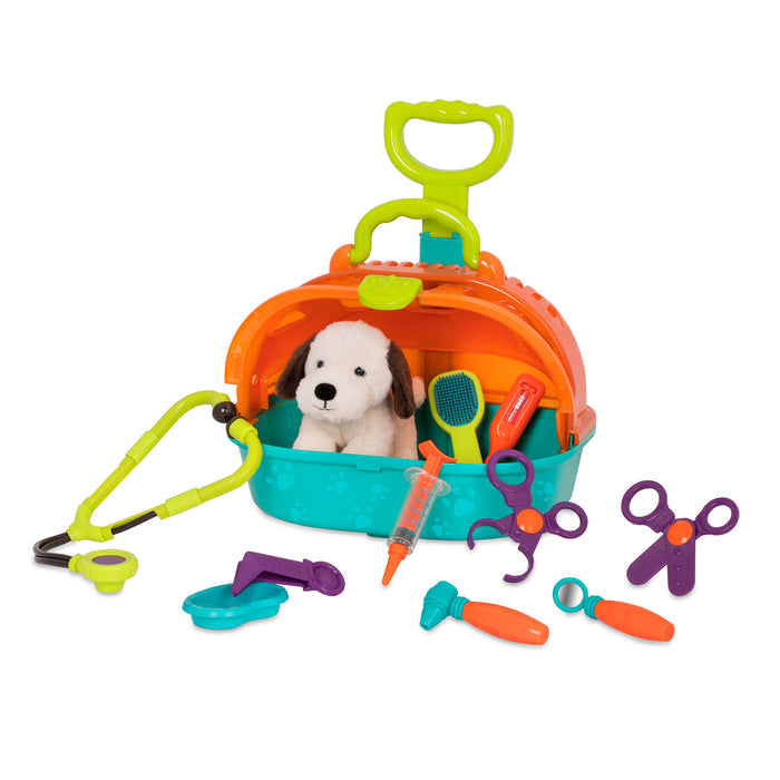 A toy pet carrier with a plush puppy inside and vet tools surrounding it.
