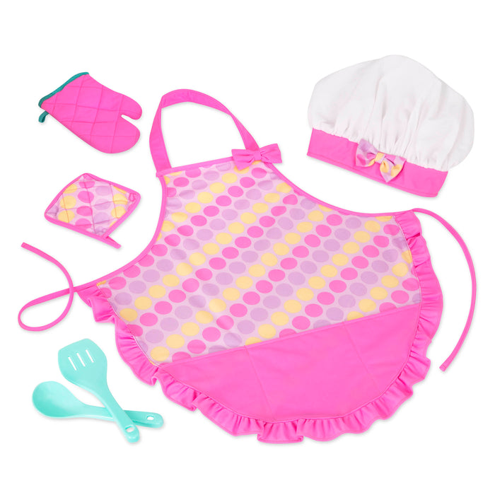 A pink apron set for kids with a chef's hat, oven mitt, and more.IThe Smart Cookie Chef's Apron in a realistc setting, there is an apron, chef's hat, oven mitt, cooking utensils and pot holder.