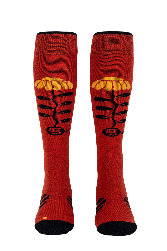 Red knee-high socks with yellow and black designs on a white background