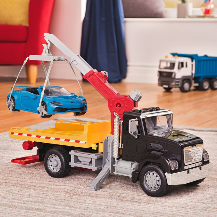 Black toy tow truck towing blue car