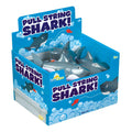 A blue display box labeled "Tub Time Pull-String Shark" by Tub Time holds several gray interactive bath toy sharks with white teeth and eyes, surrounded by cartoon bubbles and fish illustrations.