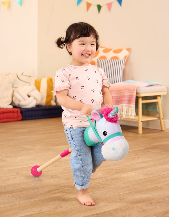 green and pink unicorn hobby horse with wooden riding pole