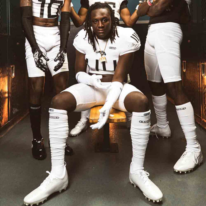Football players wearing the Battle Youth White Long Football Socks.